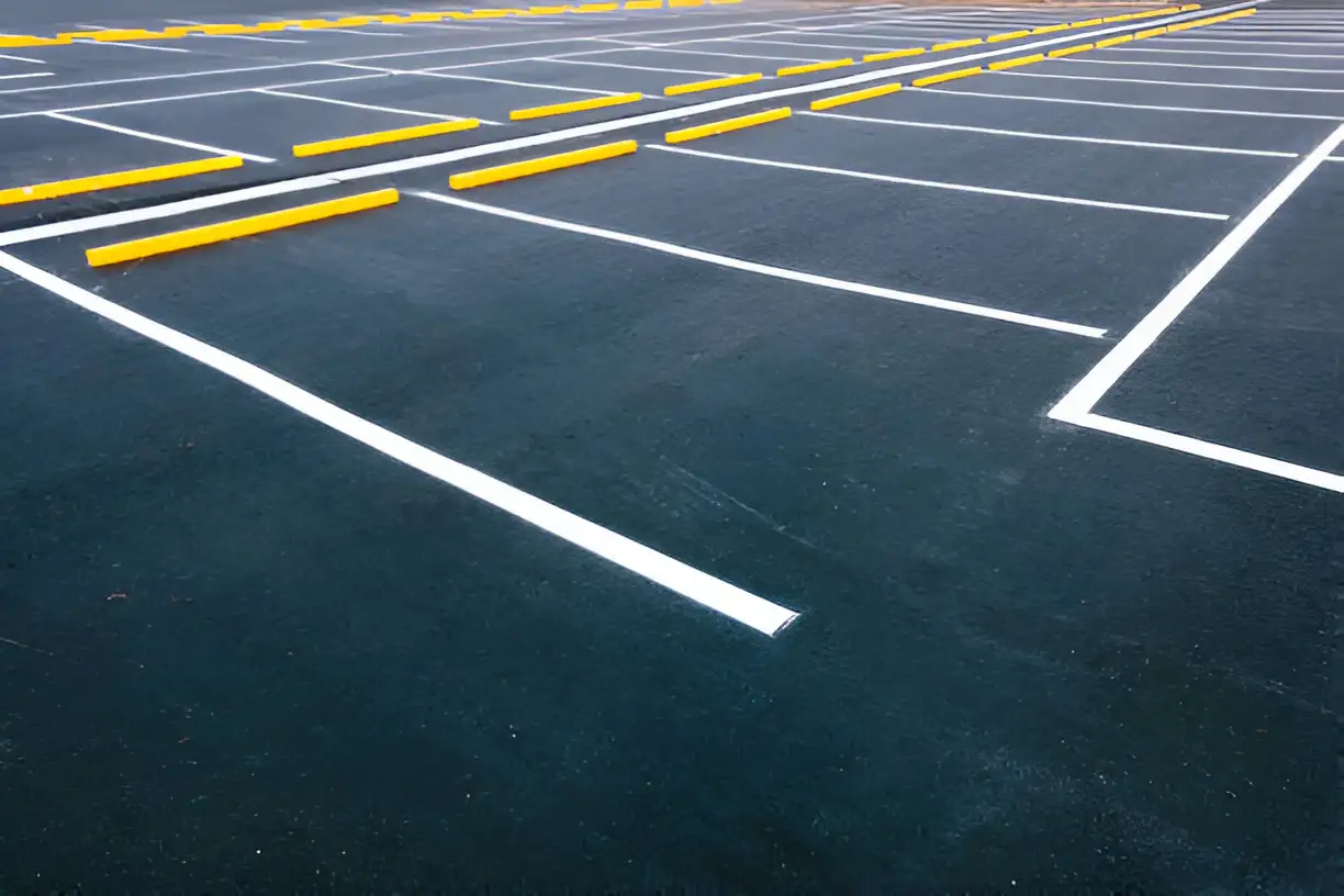 A new parking lot with fresh white stripes and yellow parking blocks
