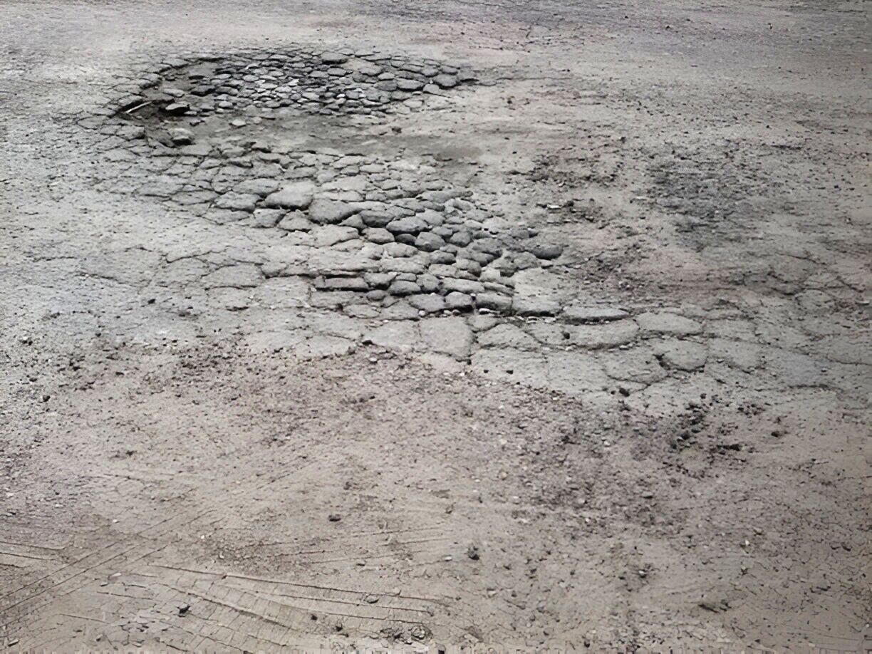 Crumbling concrete in the early stages of forming a pothole