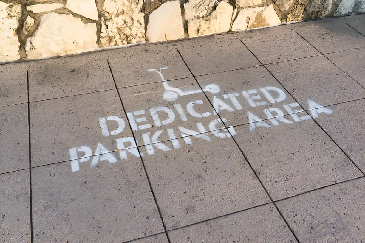 Painted sign on sidewalks that says "Dedicated Parking Area"